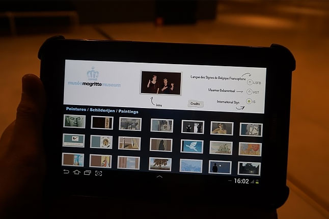 벨기에왕립미술관의 수어해설 비디오 가이드 패드. 화면의 절반에는 여러 작품이 썸네일처럼 늘어서 있고, 나머지 반에는 선택한 작품의 수어해설을 언어 옵션으로 선택할 수 있다.