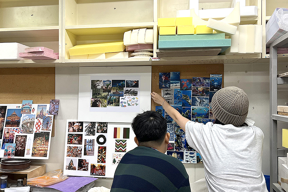 꼬물꼬물 팀원이 작업실 한 벽면에 카테고리별 관련 사진을 붙인 4개의 콘셉트 보드를 붙이고 있다. 