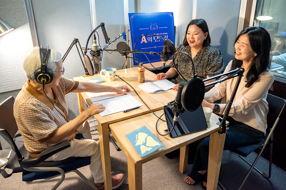 방송용 마이크가 설치된 사각 테이블에 진행자 호호(김효진)와 노평(노지영), 특별게스트 김미소 시인이 둘러앉아 이야기하고 있다.