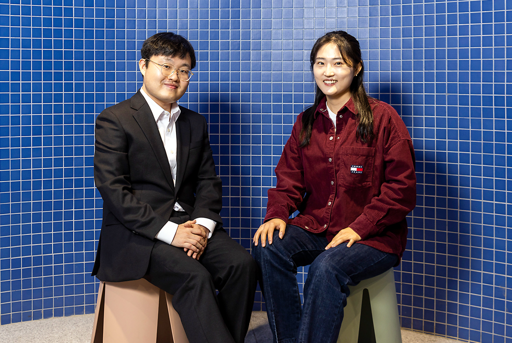 짙푸른색 타일벽 앞에 검정색 수트를 입은 방찬우 성악가와 캐주얼한 복장의 신찬미 감독이 나란히 앉아 있다.