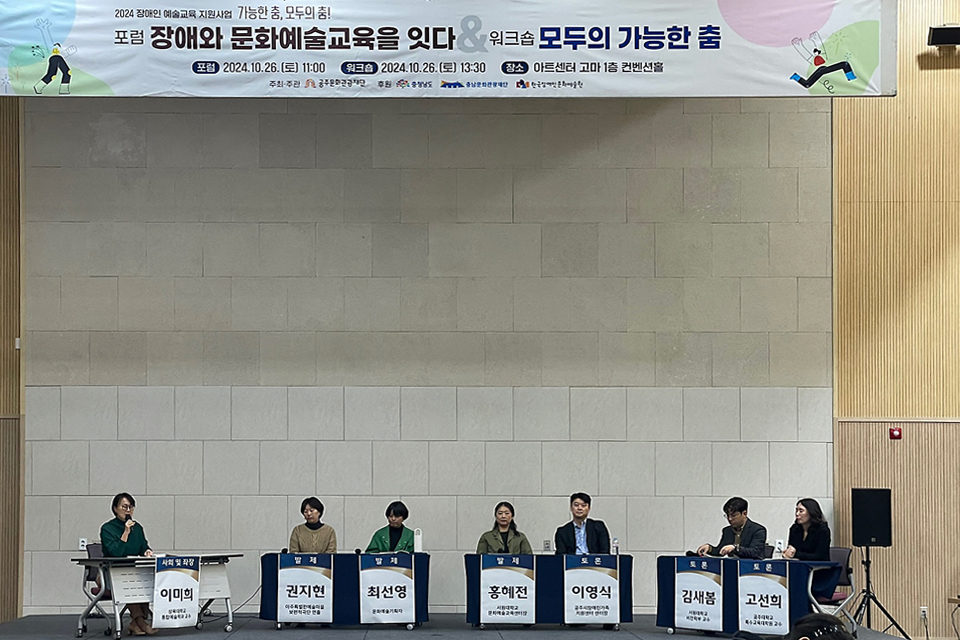 강단에 포럼 참여자들이 나란히 앉아 있다. 각 테이블 전면에는 명패가 크게 붙어 있고 “사회 및 좌장 이미희 , 발제 권지현, 발제 최선영, 발제 홍혜전, 토론 이영식, 토론 김새봄, 토론 고선희”라고 쓰여 있다.