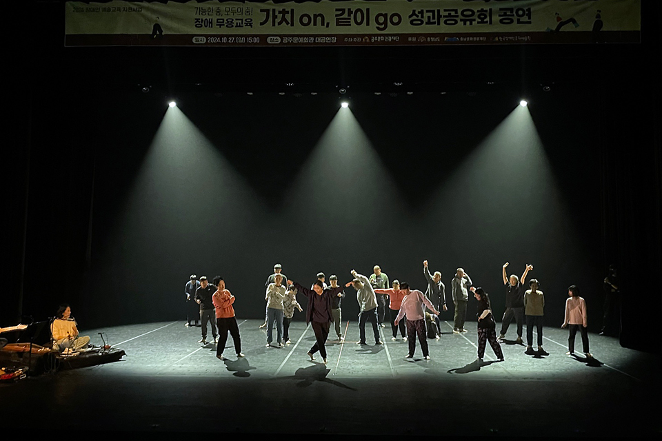 무대 왼쪽에는 연주자가 라이브연주를 하고 있고, 중앙에는 약 15명의 무용수가 춤을 추고 있다. 