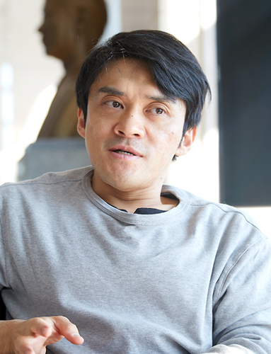 회색 옷을 입은 김원영이 오른쪽을 바라보며 이야기하고 있다.