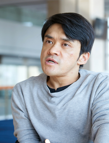 회색 옷을 입은 김원영이 왼쪽을 바라보며 이야기하고 있다.