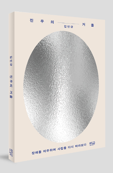 베이지색 표지 중앙에 세로로 긴 은색 타원형 거울 이미지가 은박으로 크게 배치되어 있는 책표지. 상단에 ‘진우의 거울’ ‘김인규’라고 쓰여 있고, 하단에 ‘장애를 마주하며 사람을 다시 바라보다’라고 쓰여 있다.