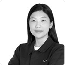 차분한 긴머리에 검은 재킷을 입은 여성이 정면을 응시하고 있다.