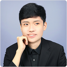 검정색 셔츠를 입은 남성이 한 팔을 턱에 괴고 있다.