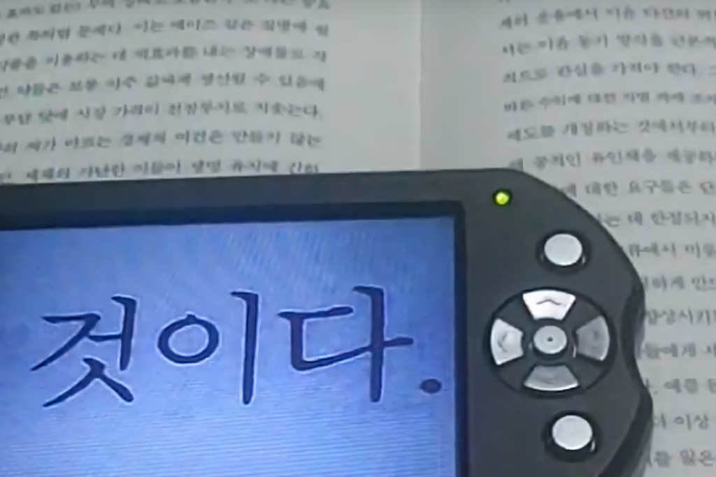 확대 기기를 사용하여 독서를 하고 있는 모습